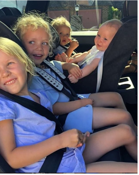 4 children in the back of a car