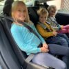 3 kids in the back of a tesla model 3