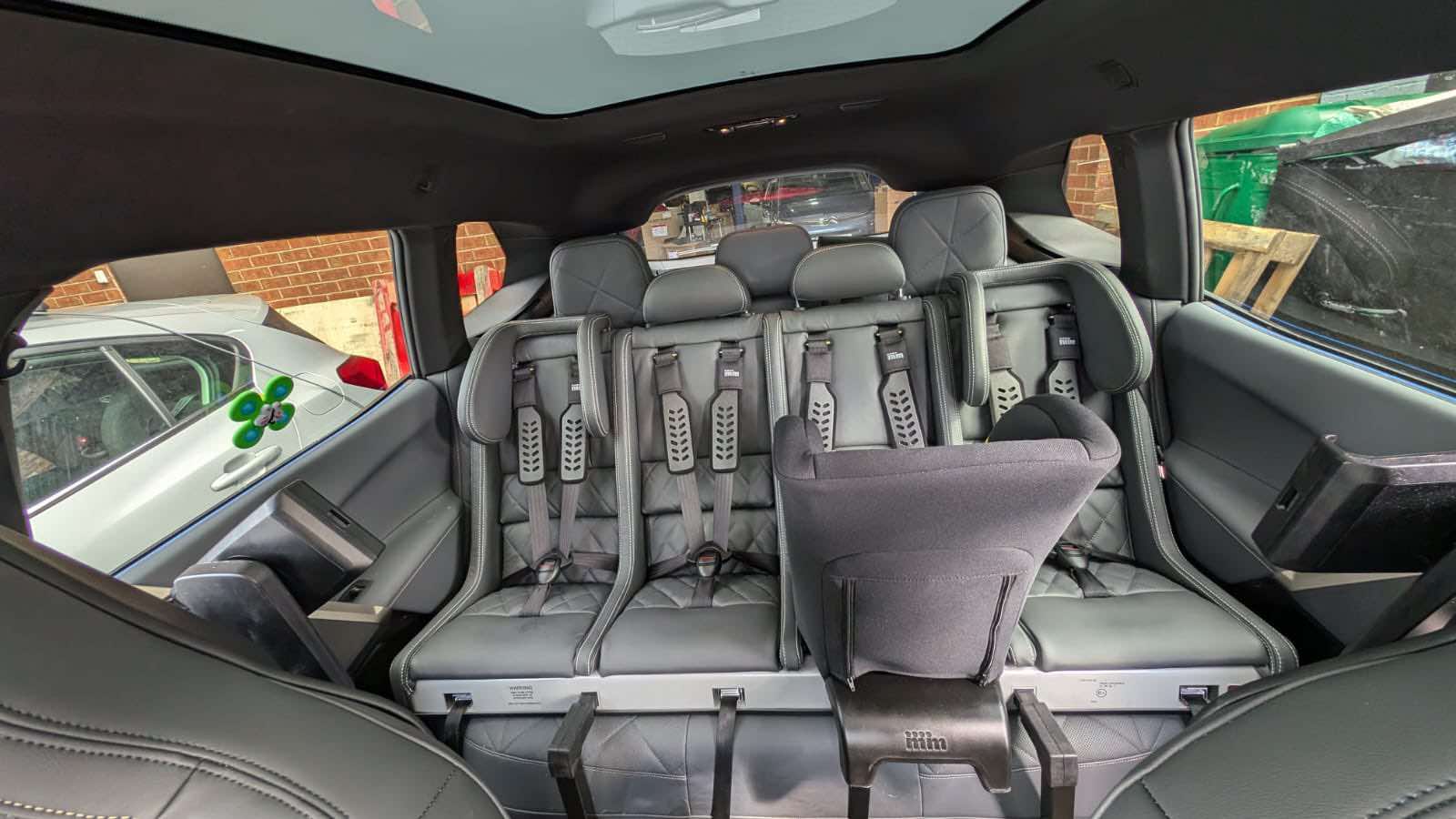 1320 in BMW iX - leather trim Leather trimmed Multimac with Minimac baby seat in rear of BMW iX trimmed to match grey interior of car